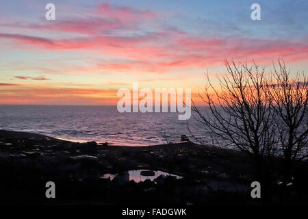 Hastings, East Sussex. 28. Dez 2015. Bunte Sonnenaufgang über dem Meer kündigt einen schönen sonnigen Tag an der Südküste. Stockfoto