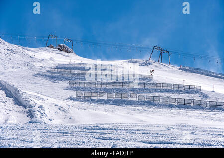 Skilift, Schneezäune und Skifahrer am Hintertuxer Gletscher in den Zillertaler Alpen in Österreich während der wind Stockfoto