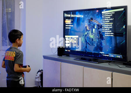 Jungen spielen Videospiel auf großen flachen Fernseher mit Flachbildschirm in England uk Stockfoto