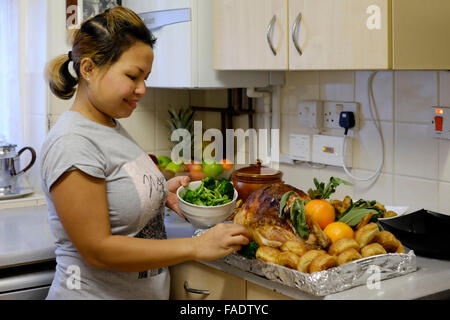 junge asiatische Frau vorbereiten traditionelle Weihnachten Türkei Abendessen in England uk Stockfoto