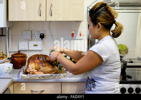 junge asiatische Frau vorbereiten traditionelle Weihnachten Türkei Abendessen in England uk Stockfoto