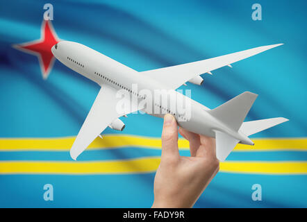 Flugzeug in der Hand mit Nationalflagge auf Hintergrund - Aruba Stockfoto