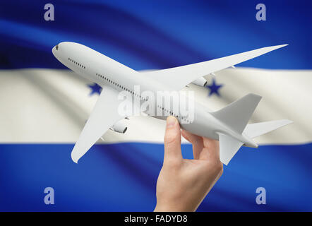 Flugzeug in der Hand mit Nationalflagge auf Hintergrund - Honduras Stockfoto