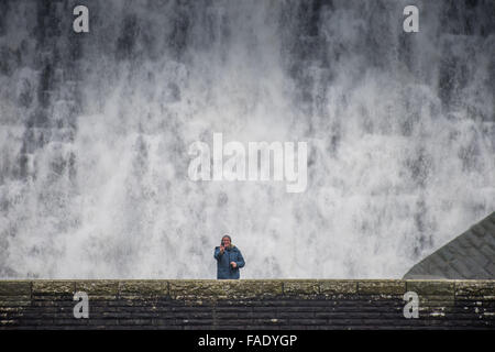 Elan-Tal, in der Nähe von Rhayader Powys Wales UK. 28. Dezember 2015.    Ein Mann auf der Fußgängerbrücke wird einer Nahaufnahme Blick auf nimmt eine Selfie, als nach Wochen des starken Regens das Wasser die Caban Coch-Talsperre in der Elan-Tal westlich von Rhayader Powys Mid Wales überragen.    Caban Coch ist die niedrigste Glied in einer Kette von 6 Talsperren und Stauseen gebaut vor hundert Jahren Einspeisung in eine 73 Meile Schwerkraft angetrieben Aquädukt der Stadt Birmingham saubere Wasserversorgung Bildnachweis © Keit: Keith Morris/Alamy Live-Nachrichten Stockfoto