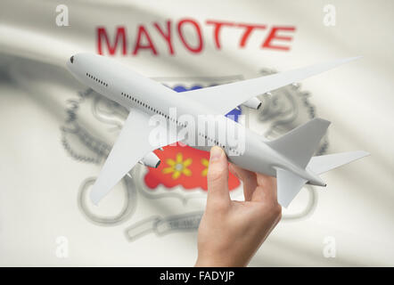Flugzeug in der Hand mit Nationalflagge auf Hintergrund - Mayotte Stockfoto