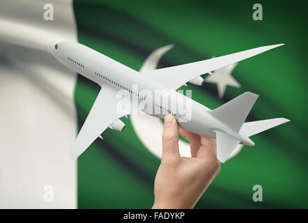 Flugzeug in der Hand mit Nationalflagge auf Hintergrund - Pakistan Stockfoto