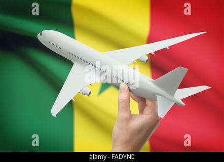 Flugzeug in der Hand mit Nationalflagge auf Hintergrund - Senegal Stockfoto