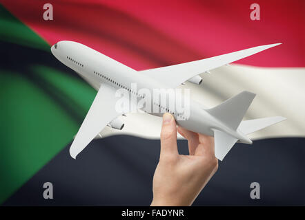 Flugzeug in der Hand mit Nationalflagge auf Hintergrund - Sudan Stockfoto