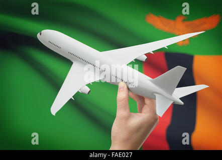 Flugzeug in der Hand mit Nationalflagge auf Hintergrund - Sambia Stockfoto