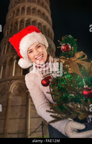 Die legendäre italienische Architektur fügt Stil der Weihnachtsfeier. Porträt der lächelnde junge Frau in Nikolausmütze mit Ch Stockfoto