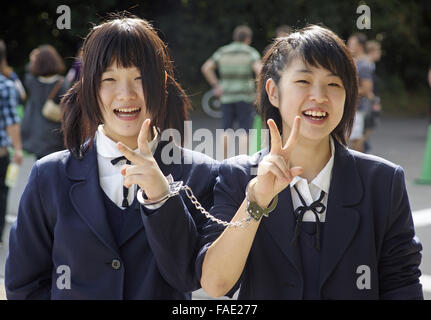 Teenager japanische Schulmädchen gefesselt zusammen in Harajuku, Tokio Stockfoto