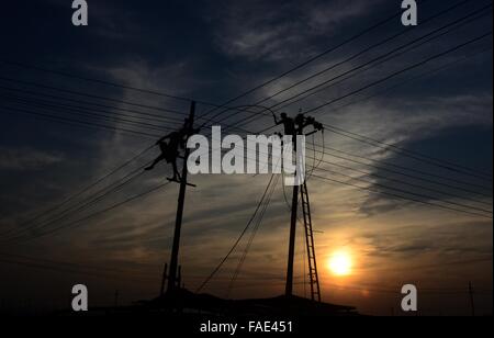 Allahabad, Uttar Pradesh, Indien. 28. Dezember 2015. Indien, Uttar Allahabad: Indische Arbeiter einstellen Stromkabel richten Sie vorübergehend an den Ufern des Flusses Ganges in Vorbereitung auf die Hindu religiösen Jahrmarkt von Magh Mela in Allahabad am 28. Dezember 2015. Die Magh Mela findet jedes Jahr an den Ufern des Triveni Sangam - Zusammenfluss der drei großen Flüsse Ganges, Yamuna und die mystischen Saraswati im hinduistischen Monat Magh entspricht bis Mitte Januar - Mitte Februar © Prabhat Kumar Verma/ZUMA Draht/Alamy Live News Stockfoto