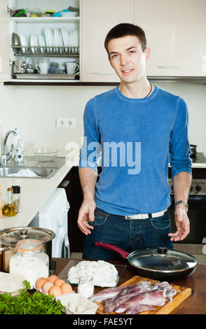 Hübscher Kerl Kochen Tintenfisch Ringe im Teig Stockfoto