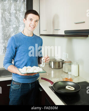 Glücklicher Kerl Kochen Tintenfisch Ringe im Teig Stockfoto