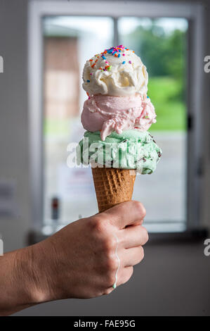 Hand, die eine drei scooped Eiswaffel Stockfoto