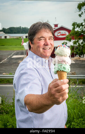 Mann hält eine drei scooped Eiswaffel vor seinem creamery Stockfoto