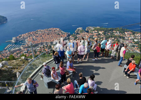 Touristen auf eine Aussichtsplattform mit der Altstadt und Festung in der Ferne, Dubrovnik, Kroatien. Stockfoto