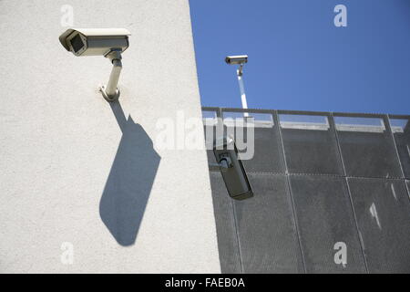 Weiße Sicherheits-Kameras an der weißen Wand montiert Stockfoto