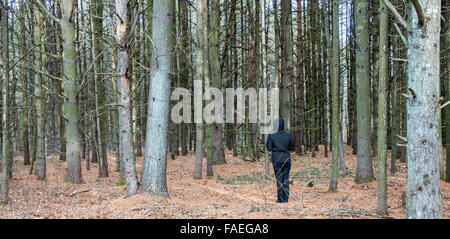 geheimnisvolle Person in der schwarzen Stellung im Wald Stockfoto