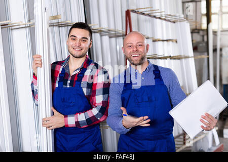 Sorgfältige Arbeiter in Uniform in Drehbank, seinen Chef mit Papieren in der Nähe in Betrieb Stockfoto