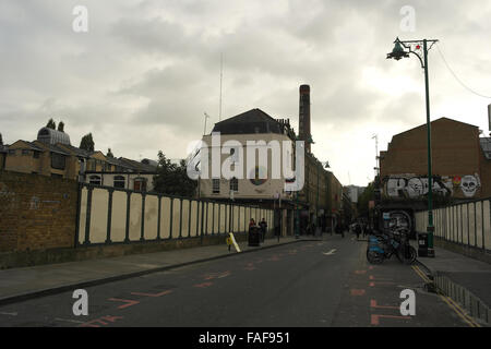 Graue Wolken Blick über Great Eastern Railway Bridge, Graffiti-Gebäude und alte Truman Brauerei Schornstein, Brick Lane, London Stockfoto