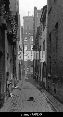 Blick in Die Holzgasse Mit Blick Auf Einen Turm der Trinitatiskirche in Köln, Deutschland 1920er Jahre. Blick auf Holzgasse Lane mit Blick auf eine der die Glockentürme der Trinity Church in Köln der 1920er Jahre. Stockfoto