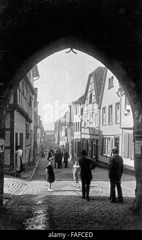 Menschen Unter Einem Stadttorbogen in Einer Kleinstadt in der Eifel, Deutschland 1920er Jahre. Die Leute an einem Torbogen von einem alten Stadttor in eine Stadt in der Eifel, Deutschland der 1920er Jahre. Stockfoto