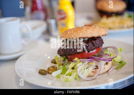 Großes amerikanisches Rindfleischburger in Brötchen essen Stockfoto