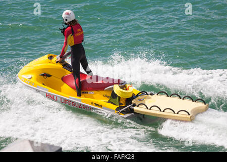 RNLI-Rettungsschwimmer Jetski mit Rettungsschwimmer standen im August in Bournemouth, Dorset, Großbritannien, auf See Stockfoto