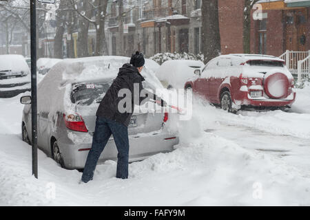 Montreal, Kanada. 29. Dezember 2015. Man reinigt Schnee aus seinem Auto beim ersten Schnee-Sturm der Saison. Bildnachweis: Marc Bruxelle/Alamy Live-Nachrichten Stockfoto