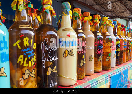 Traditionelle aromatisierte Rumflaschen auf dem Schreibtisch eines Marktes stall in Sainte Anne, Guadeloupe Stockfoto