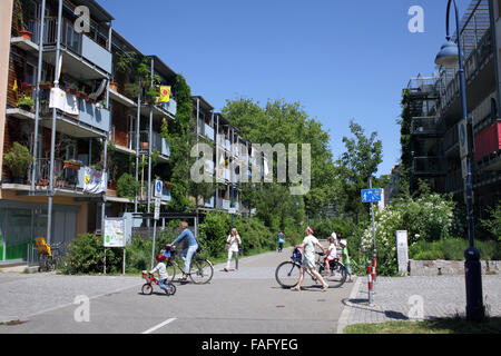 Gehäuse und Radfahrer im grünen Stadtteil Vauban, Freiburg, Deutschland. Stockfoto