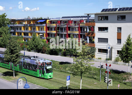 Eine Straßenbahn im grünen Stadtteil Vauban, Freiburg, Deutschland. (Beachten Sie Sonnenkollektoren auf den Dächern.) Stockfoto