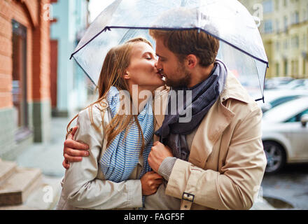 Verliebten jungen Paar Teilen zarten küssen unter Dach Stockfoto