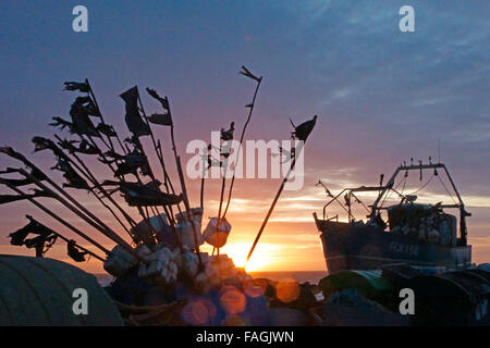 Hastings, East Sussex, 30. Dezember 2015. UK Wetter: Winter Sonnenaufgang über die Fischerboote an der Hastings Stade Strand. Stockfoto