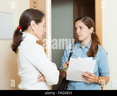 Weibliche Sammler wird versuchen, die Schulden von Reife Frau zu Hause Stockfoto