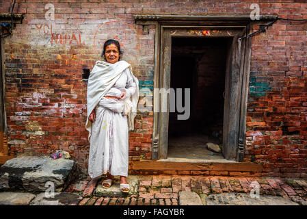 Ältere Dame steht vor ihrem Haus in Kathmandu Stockfoto