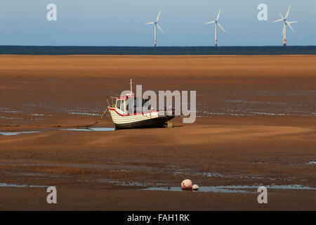 Gestrandeten Fischerboot und Offshore-Windkraftanlagen Stockfoto