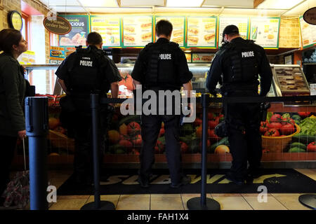 Eine Gruppe von uniformierten Polizisten Ort essen Aufträge in einer U-Bahn fast food in Washington DC. Sie sind alle bewaffnet und einer kurzen Pause von ihren Stockfoto