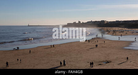 Menschen zu Fuß auf Tynemouth Strand im Nordosten Englands. Tynemouth Pier nur in die Nordsee. Stockfoto