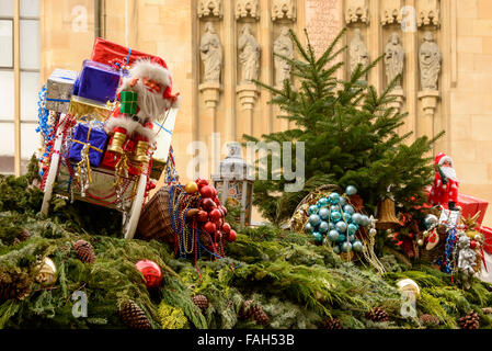 Glaskugeln und Santa Puppe zwischen Fichte Zweige auf Dach der Weihnachten Marktstand, Stuttgart, Deutschland Stockfoto