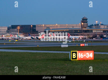 Beleuchtete Piste Signalisations- und belebten Boden Verkehr in der Abenddämmerung am internationalen Flughafen Zürich. Stockfoto