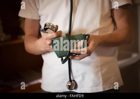 Arzt hält eine Blutdruckmanschette und tragen ein Stethoskop Stockfoto
