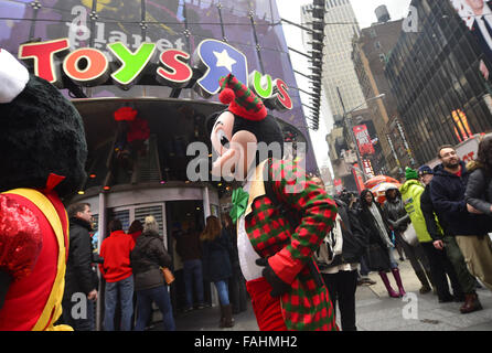 New York, USA. 30. Dezember 2015. A Street Performer gekleidet wie Mickey Mouse vorbei an Toys'R Spaziergänge ' uns Flagship-Store am Times Square in New York, USA am 30. Dezember 2015. Toys ' uns schließt seinen ikonischen Flagship-Store am Times Square Mittwoch aufgrund steigender mieten Kosten. Bildnachweis: Wang Lei/Xinhua/Alamy Live-Nachrichten Stockfoto