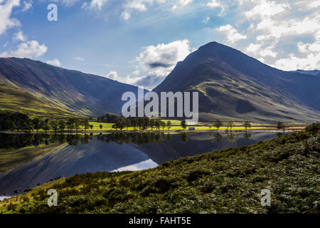 Lake Buttermere reflektieren die umliegenden Hügel an einem hellen sonnigen frühen Herbsttag Stockfoto