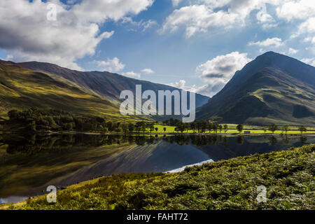 Lake Buttermere reflektieren die umliegenden Hügel an einem hellen sonnigen frühen Herbsttag Stockfoto