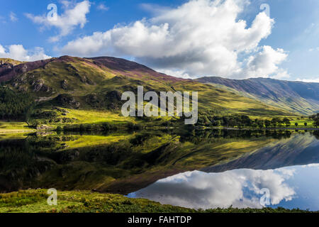 Lake Buttermere reflektieren die umliegenden Hügel an einem hellen sonnigen frühen Herbsttag Stockfoto