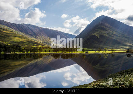 Lake Buttermere reflektieren die umliegenden Hügel an einem hellen sonnigen frühen Herbsttag Stockfoto