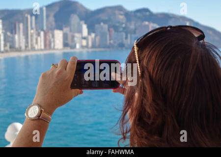 Benidorm Alicante Provinz Costa Blanca Spain Reife Frau Foto der Küste mit mobilen Handy Stockfoto