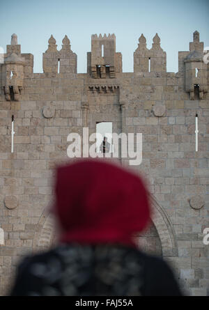 Peking, China. 16. Oktober 2015. Eine Palästinenserin betrachtet, während ein Polizist der israelischen Grenze auf dem Wall von Damaskus-Tor in der Altstadt von Jerusalem, am 16. Oktober 2015 positioniert ist. © Li Rui/Xinhua/Alamy Live-Nachrichten Stockfoto